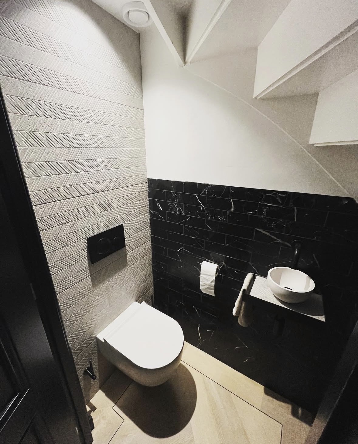 Moderne toiletruimte met zwart marmer en visgraat tegels
