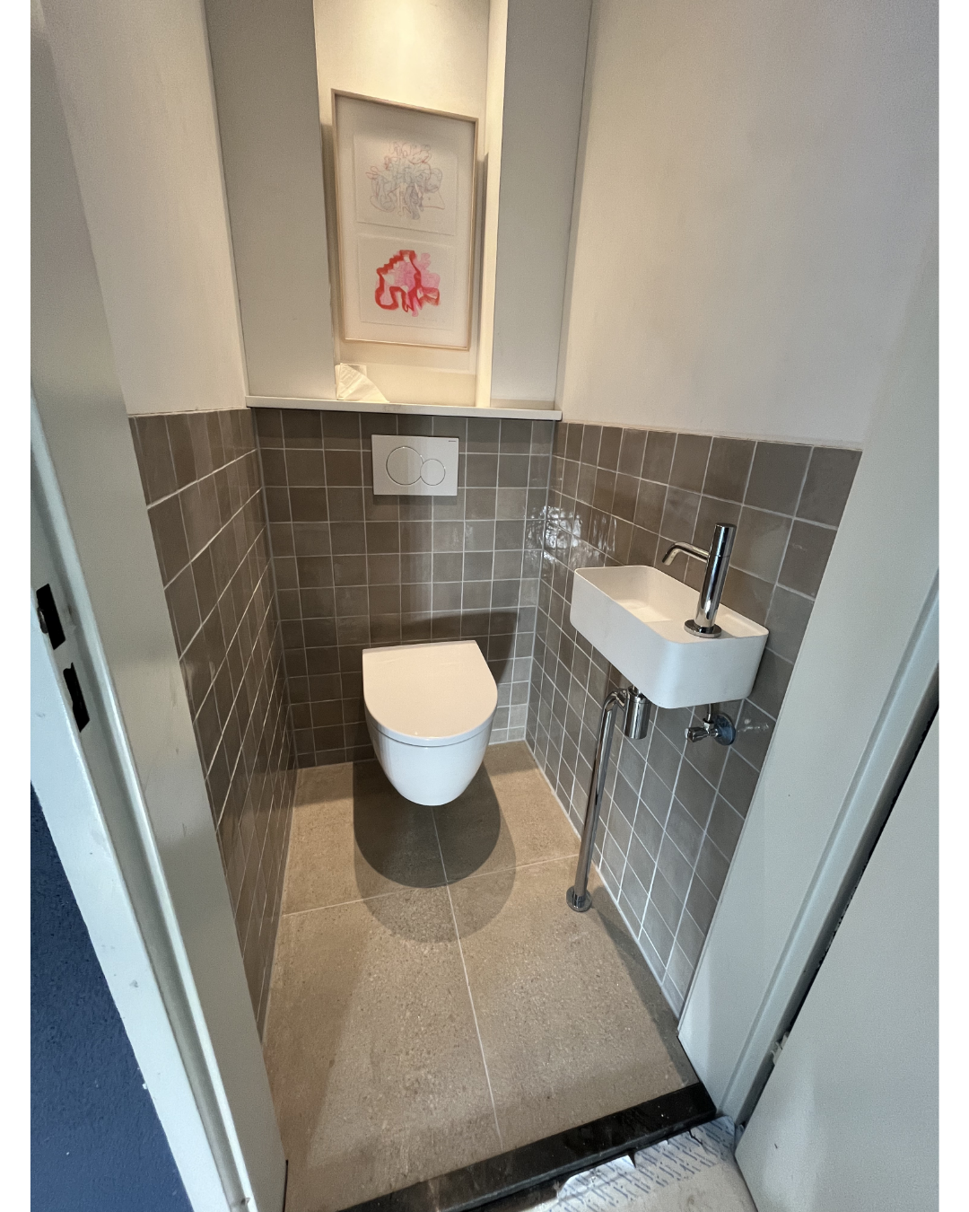 Moderne toiletruimte met grijze tegels en fontein